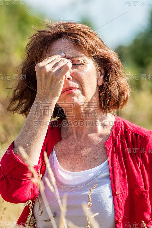 美丽成熟的女人与雀斑遭受热潮红的户外