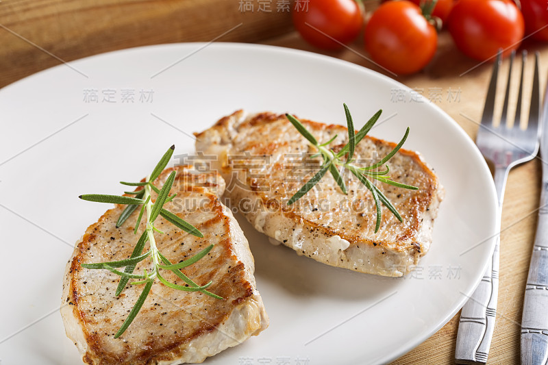 Fried pieces of pork chop with rosemary