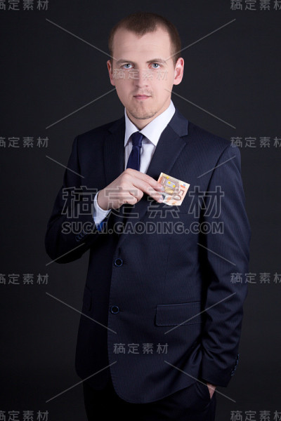 西装革履的男人把欧元钞票放进口袋