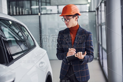 工人在保护头盔和记事本看现代汽车