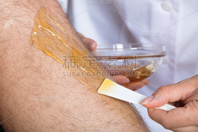 美容师给男人的腿脱毛
