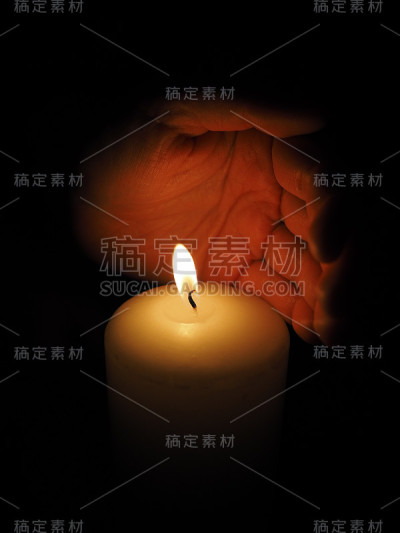 蜡烛和手放在黑色背景上