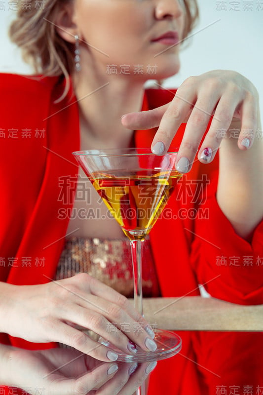 画一个漂亮的金发女孩穿着红色夹克和一杯马提尼