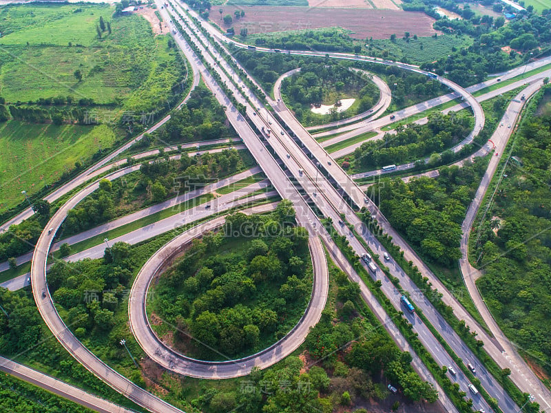 鸟瞰图，道路环岛，高速公路与汽车停车场在泰国的城市。美丽的街道，市中心，城市景观，顶视图。背景