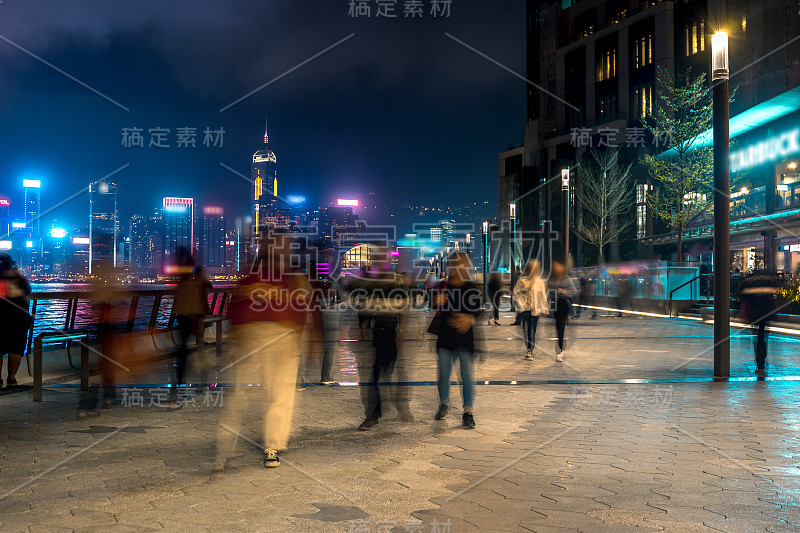 香港城市夜景。在海滨散步的游客