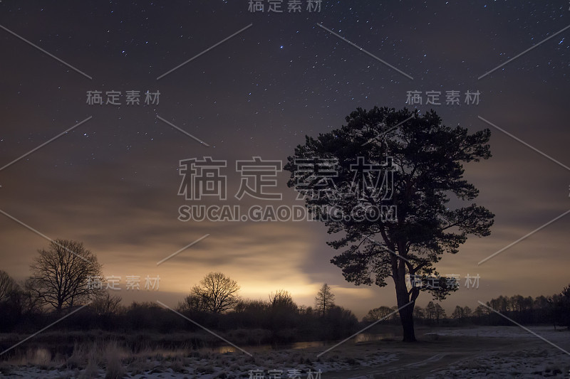 夜景的星空和多云的天空与树在岸边河。大自然寒冷的冬夜。