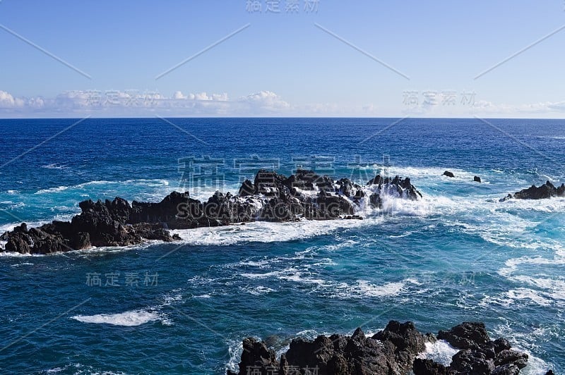 海浪冲击着大西洋上的黑色火山岩(葡萄牙马德拉的莫尼兹港)