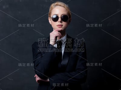 典型的女商人穿着黑色西装，戴着墨镜