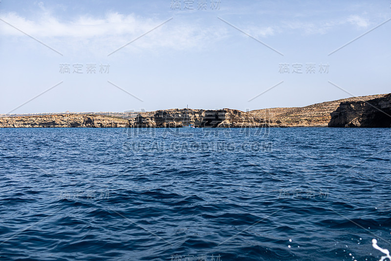 大海里的岩石。海岸的背景是山坡。海景与山地景观。一张海景照片。