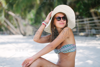 美丽的女人坐在沙滩上