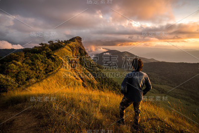 年轻的旅行者在看山上美丽的日出