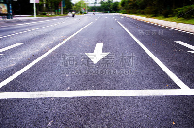黑色柏油路上的白色箭头