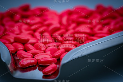 微距拍摄细节红肾形状糖衣片剂药丸在不锈钢药盘