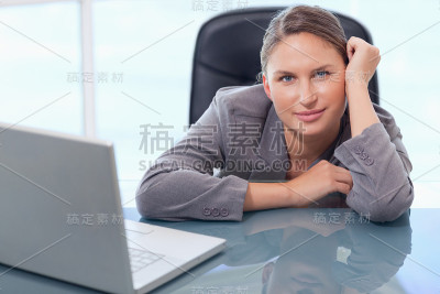 年轻的女商人靠在桌子上