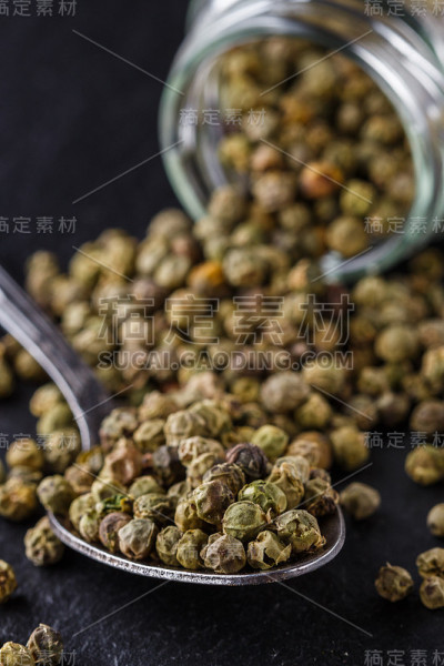 绿色的花椒在深色石板石的背景上