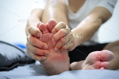 男人与疼痛和发炎痛风在他的脚周围的大脚趾区域。