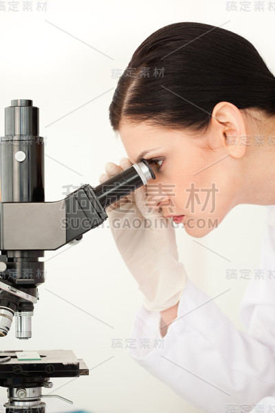 通过显微镜观察的女科学家
