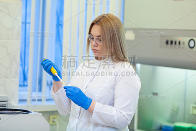 在医学或科学实验室中使用实验室移液管并将样品装入离心机的技术人员
