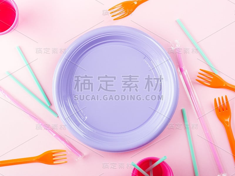 一次性彩色塑料盘、吸管和玻璃