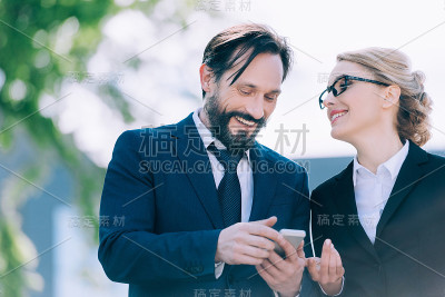 愉快的中年商业同事一起使用智能手机