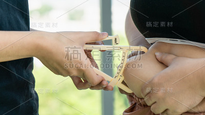 手持卡尺测量胖胖女人腹部的脂肪厚度