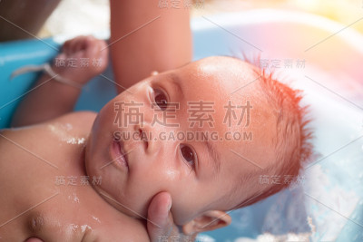 妈妈用太阳光在浴室里给小女孩洗手。