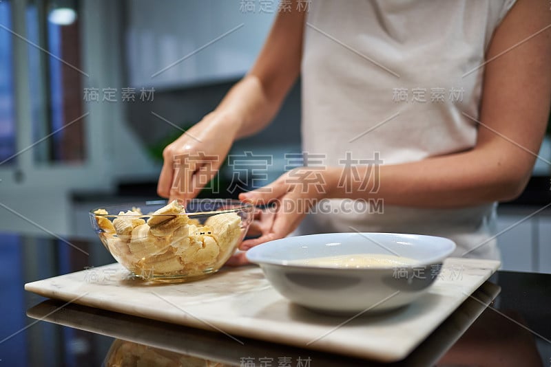 一个女人的手压碎香蕉做香蕉煎饼的特写