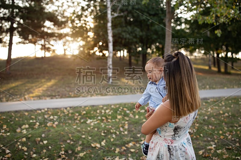 年轻的母亲和男婴在大自然中行走