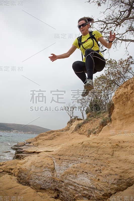 一个女人拿着运动器材在海岸线上跳。克罗地亚达尔马提亚地区，Starigrad的Paklenica。