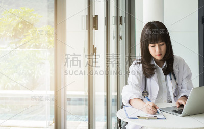 女医生拿着笔在医院或诊所写病人治疗后的报告，以健康的观念。