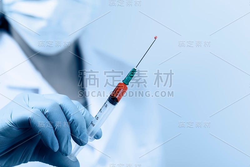 女医生工作与注射器针头和安瓿药。一位穿着无菌衣服的科学家正在研制疫苗药物