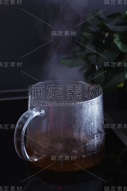 在陶瓷灶台上的透明玻璃锅中自然滴煮，散发出美丽的水蒸气