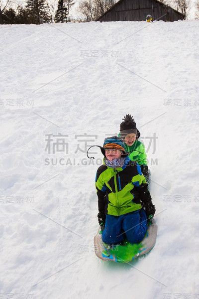 男孩们骑着雪橇，在雪地上滑行