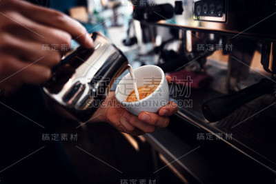 拉近咖啡师准备卡布奇诺的双手。