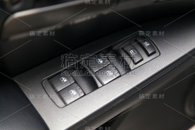 在一辆豪华现代汽车中，用于开启和关闭车窗的控制按钮和带有内饰的灰色门上的电动控制。