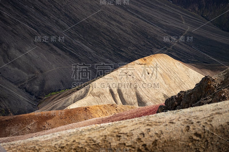 landmanalaugar彩色山丘上的黑灰背景在拉格维格徒步旅行小径。冰岛。由多种颜色的岩石、矿物