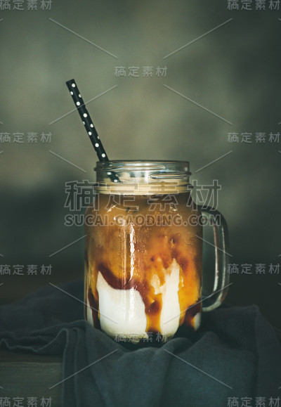 冰焦糖玛奇朵咖啡与牛奶的罐子在桌子上