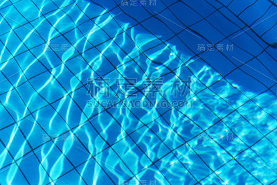 在游泳池的蓝色水中嬉戏的光
