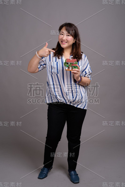 工作室拍摄的成熟美丽的亚洲女商人在灰色的背景