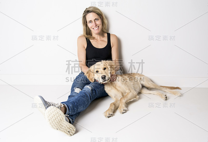 漂亮的女人和她美丽的金毛猎犬在白色的背景