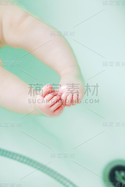 特写照片可爱的新生儿的脚在洗澡水。