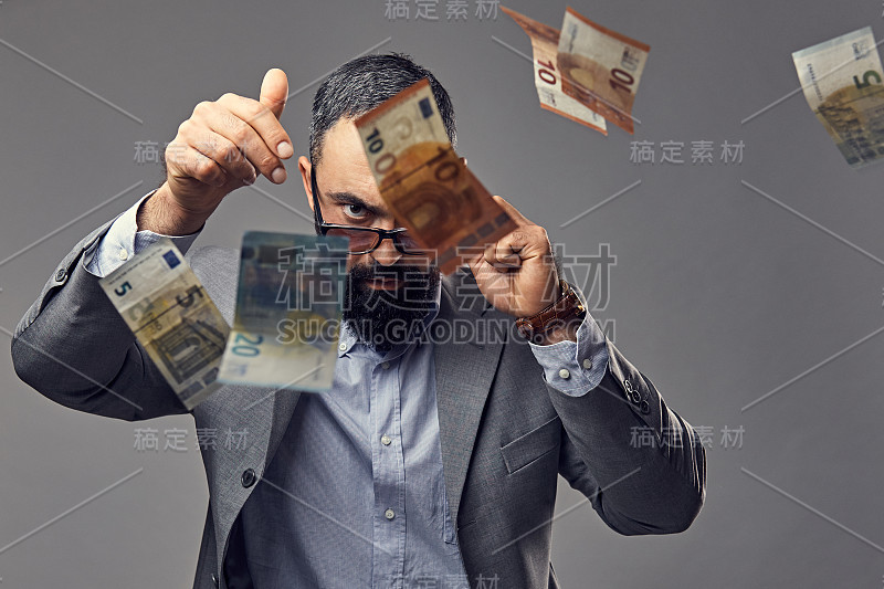 一个男人在空中抓住了钞票。