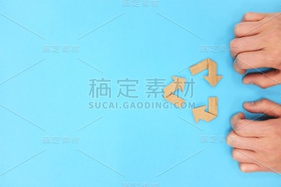 回收符号由纸板纸平铺组成。蓝色背景与复制空间。