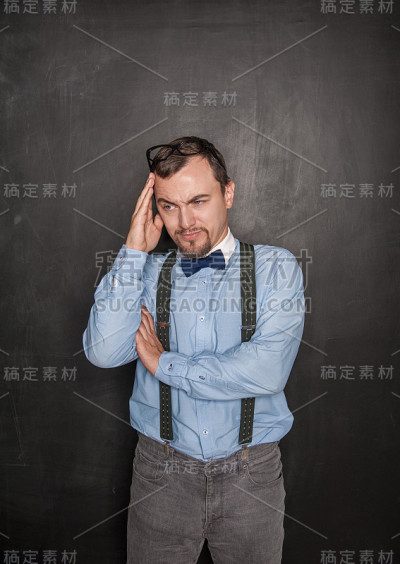 体贴帅气的老师在黑板背景上
