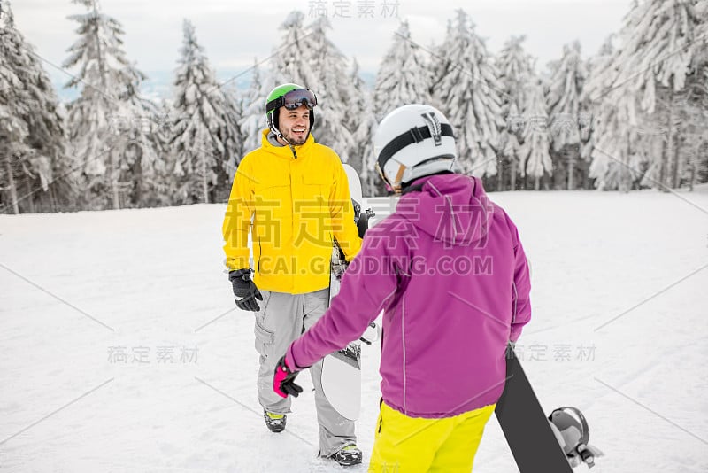 在雪山上玩滑雪板