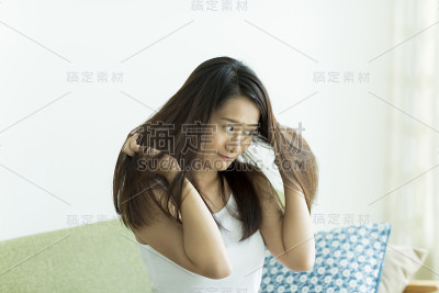 年轻女子在摸她的头发