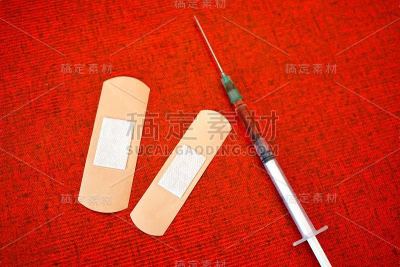 红色背景上有注射器和石膏