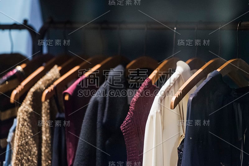 在米兰的一家商店里，女人的衣服挂在衣架上。