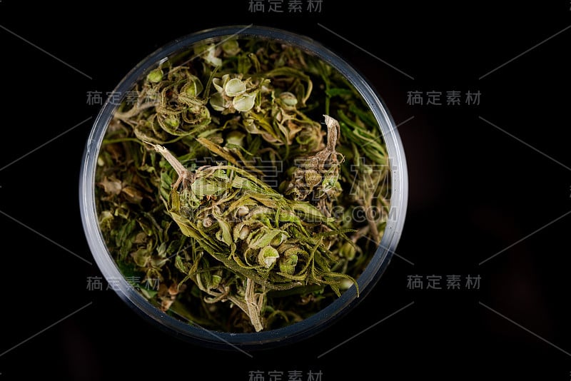 大麻花蕾在玻璃罐，从上到下近。黑暗的背景。医用大麻的概念