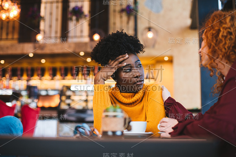 两个女性朋友在谈论其中一人的问题。红头发的女孩支持和理解。